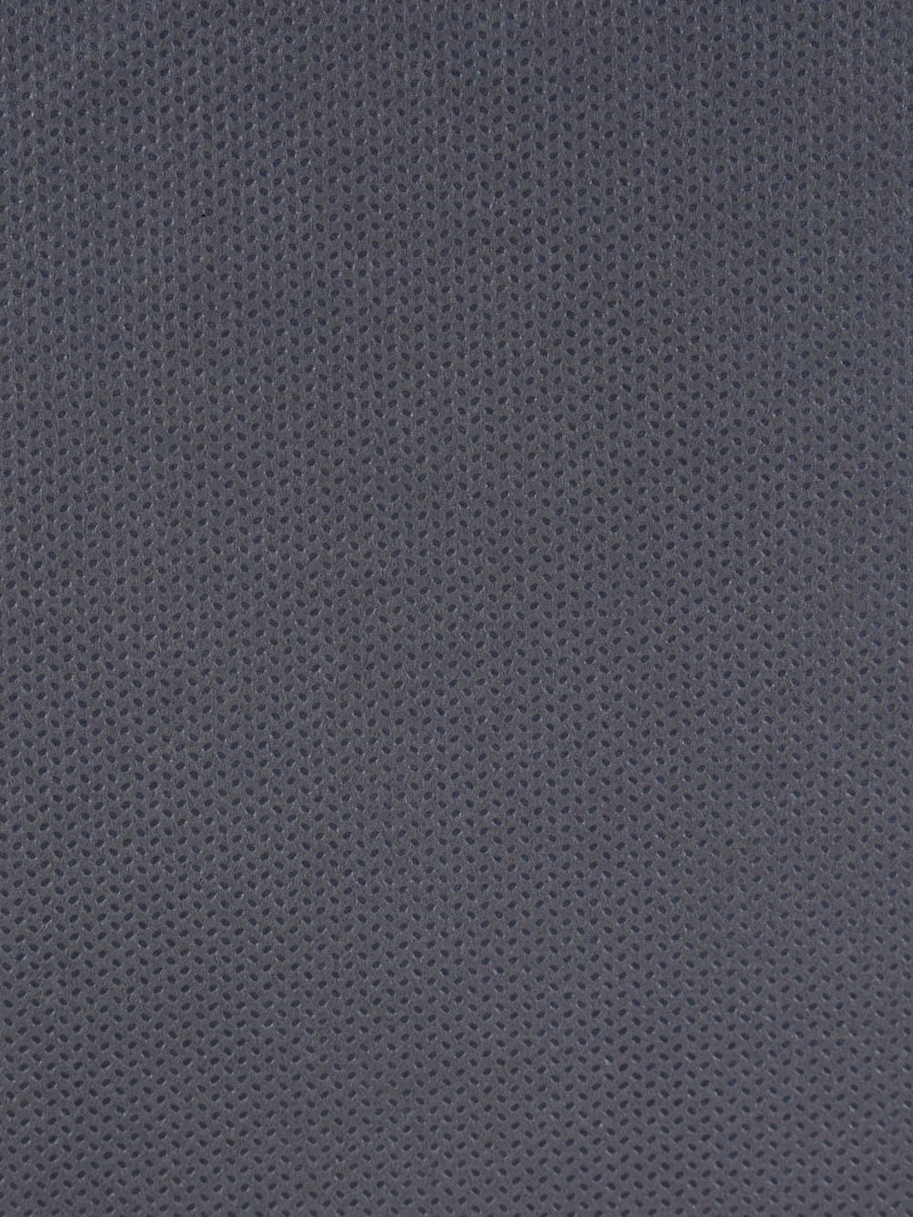 Close view of a stretch-knit fabric, the fine elastic filaments visible where the weave pulls.